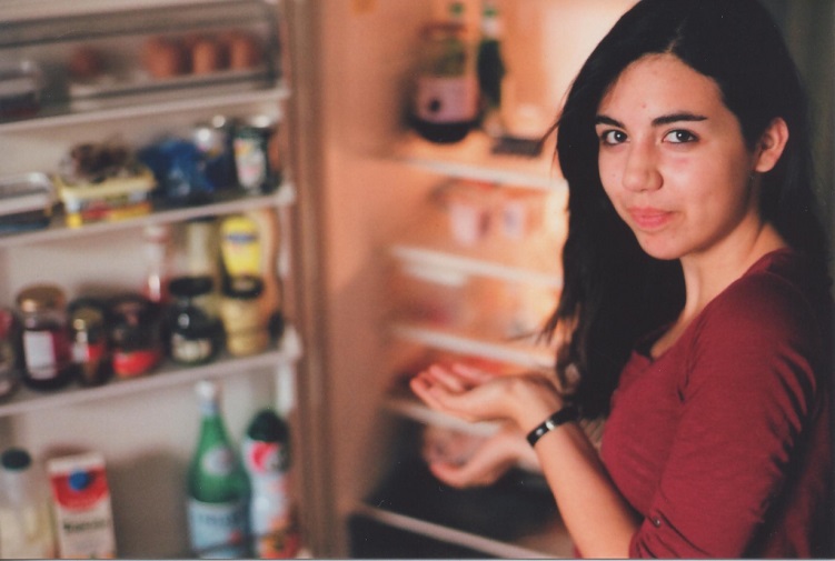 woman standing by an open fridge